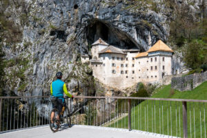 Cyclists visiting Predjama Castle near Postojna, Slovenia