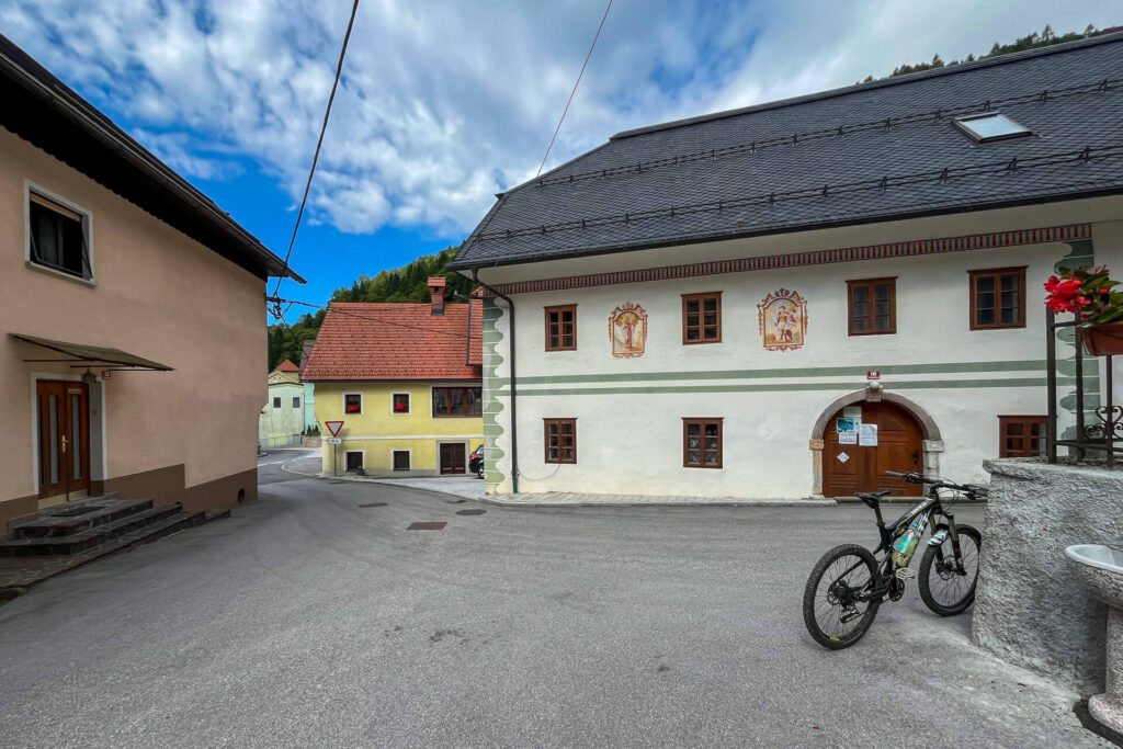 In front of the tourist information center in the center of Podbrdo, next to a new water tap.