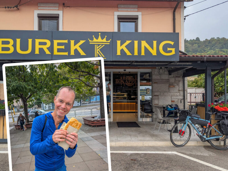 Cyclist trying out burek on Trans Dinarica.