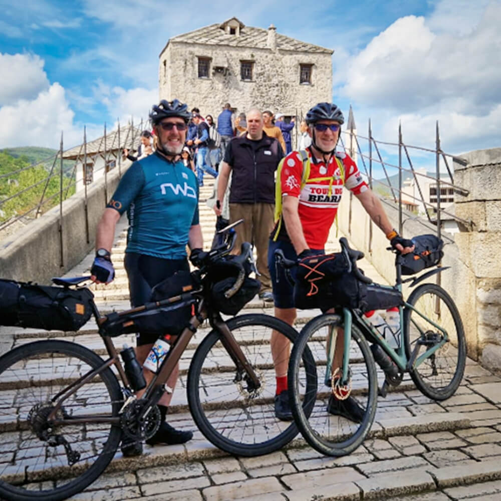 Two Trans Dinarica bikepackers on the Old bridge in Mostar, Bosnia and Herzegovina.